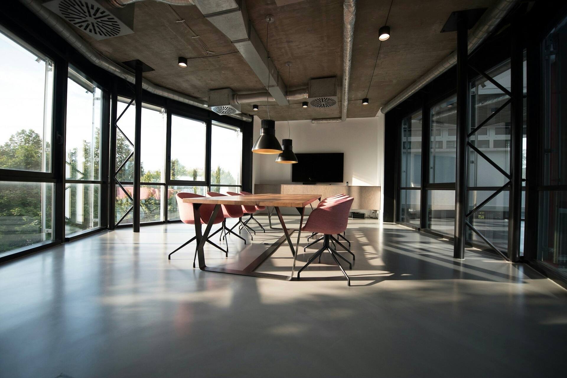 A commercial meeting room finished in polished concrete, glazed on two sides