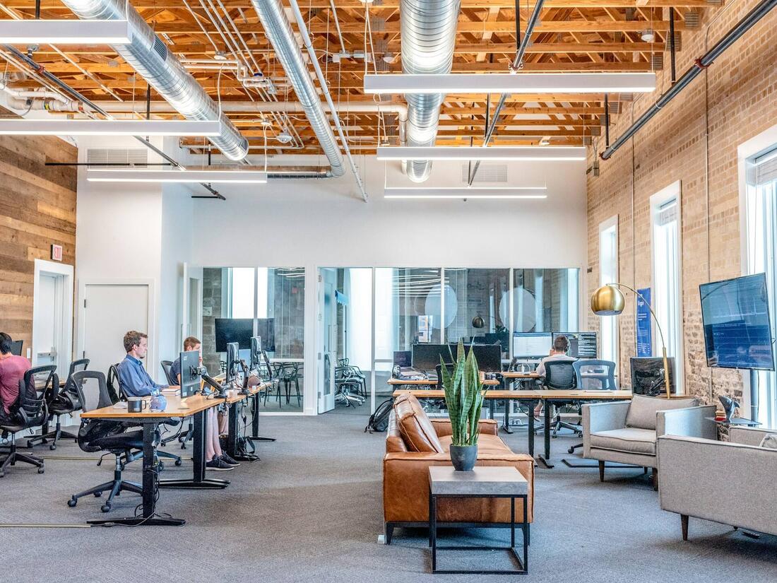 Open-plan office workspace on a wide engineered-wood floor