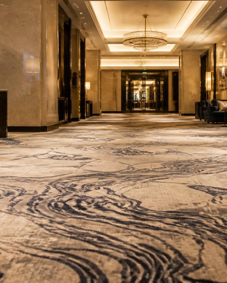 Patterned broadloom carpet running the length of a hotel corridor
