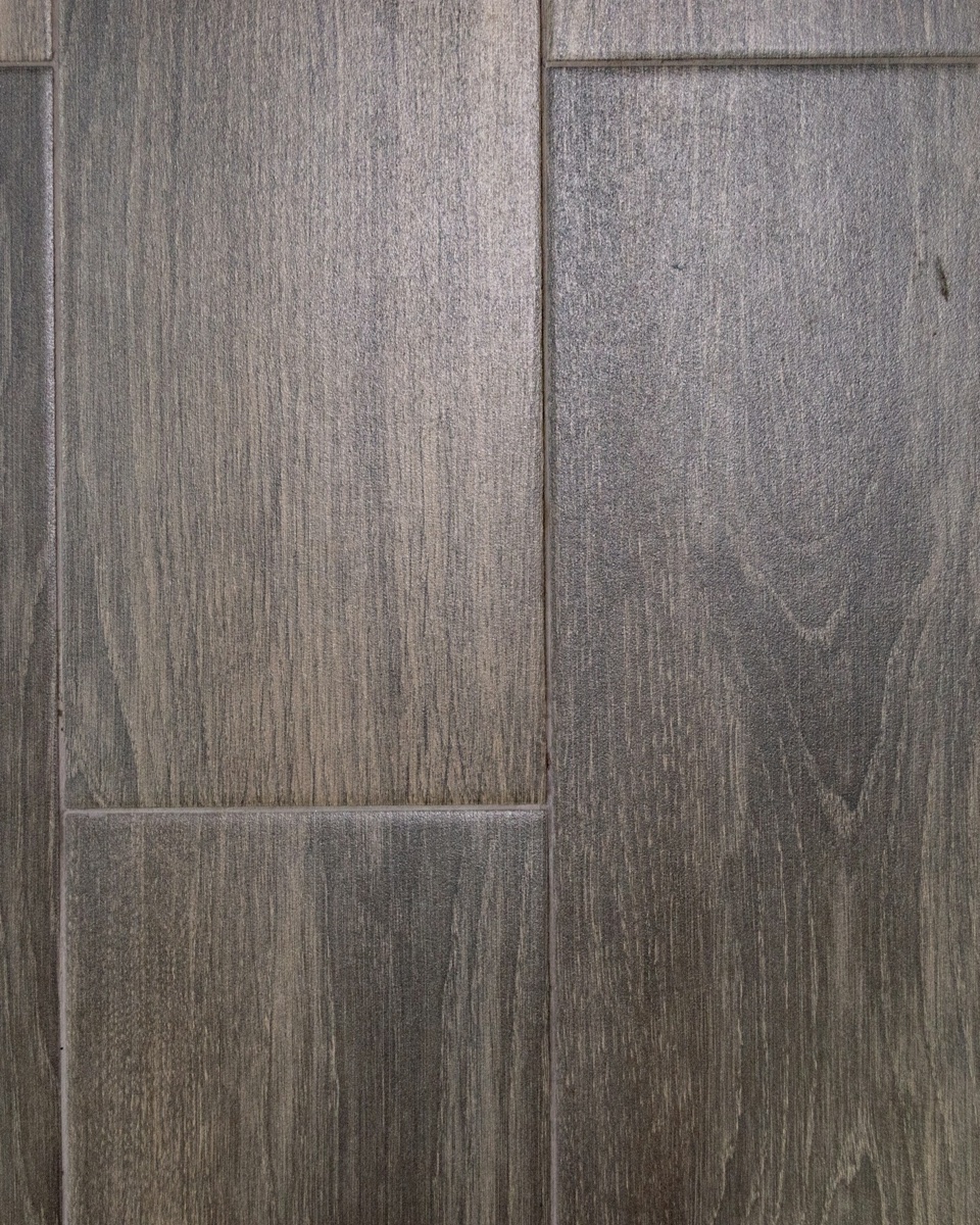 Close detail of a wood-effect vinyl plank floor, joints and grain visible